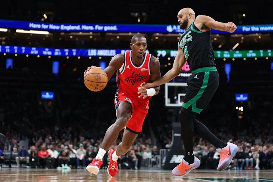 Nov 16, 2025; Boston, Massachusetts, USA; Los Angeles Clippers guard Kris Dunn (8) drives to the basket defended by Boston Celtics guard Derrick White (9) during the second half at TD Garden. Mandatory Credit: Paul Rutherford-Imagn Images