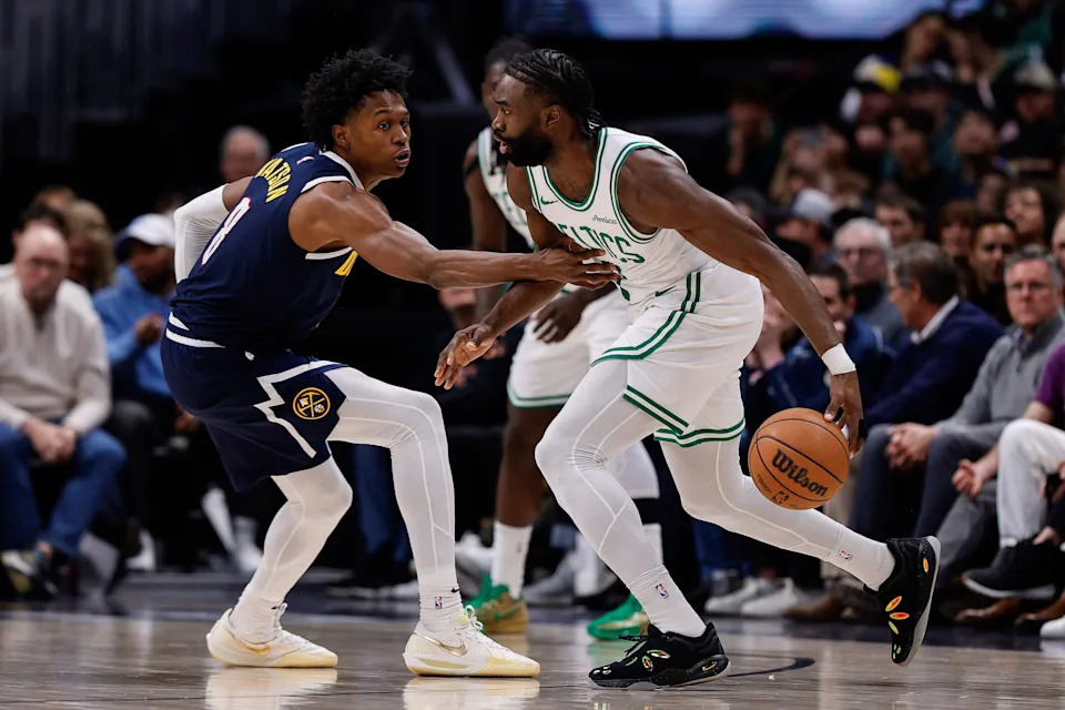 Jan 7, 2025; Denver, Colorado, USA; Boston Celtics guard Jaylen Brown (7) controls the ball as Denver Nuggets forward Peyton Watson (8) guards in the second quarter at Ball Arena. Mandatory Credit: Isaiah J. Downing-Imagn Images