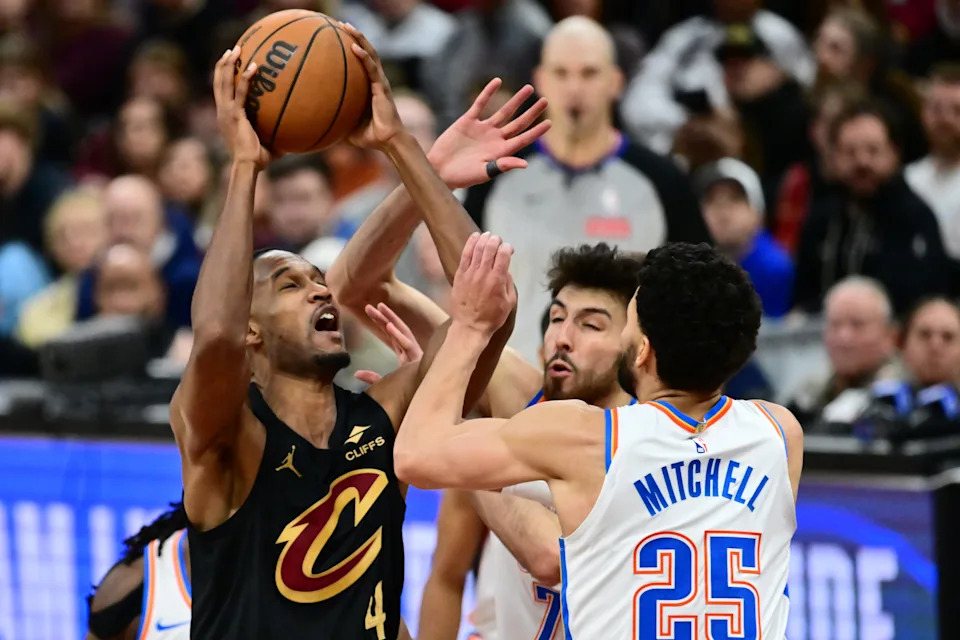 Jan 19, 2026; Cleveland, Ohio, USA; Cleveland Cavaliers center Evan Mobley (4) drives to the basket against Oklahoma City Thunder center Chet Holmgren (7) and guard Ajay Mitchell (25) during the second half at Rocket Arena. Mandatory Credit: Ken Blaze-Imagn Images