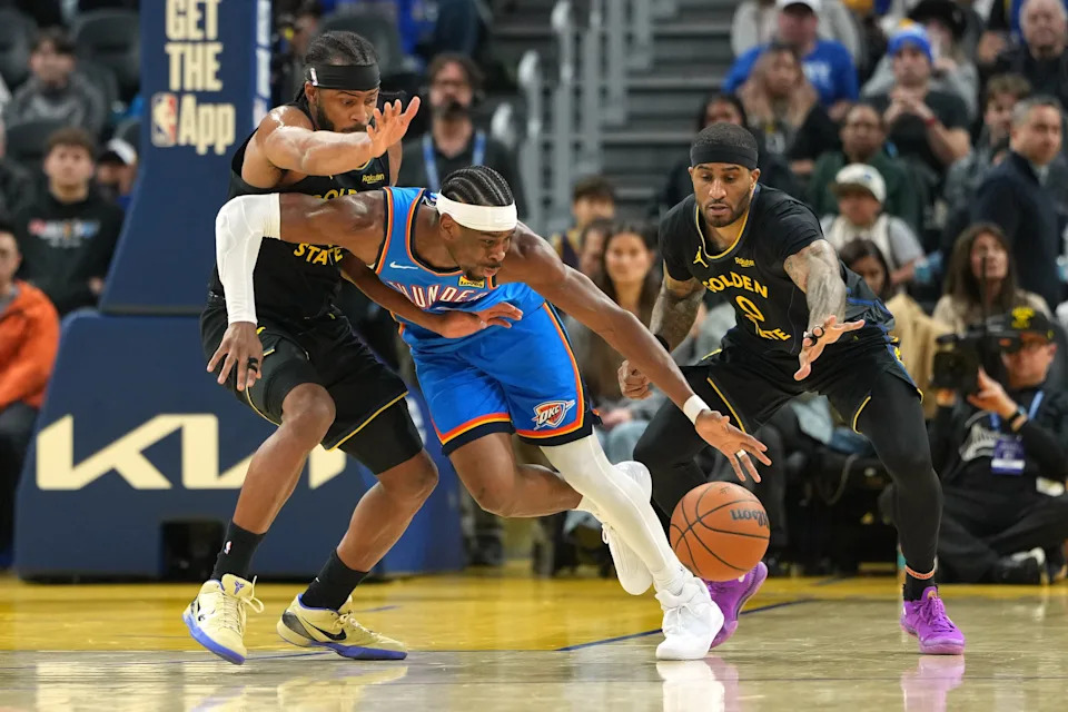 Jan 2, 2026; San Francisco, California, USA; Oklahoma City Thunder guard Shai Gilgeous-Alexander (center) dribbles against Golden State Warriors guards Moses Moody (left) and Gary Payton II (0) during the second quarter at Chase Center. Mandatory Credit: Darren Yamashita-Imagn Images