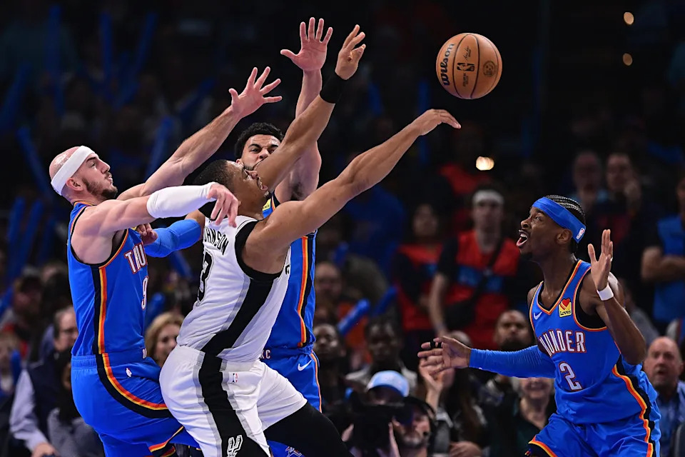 OKLAHOMA CITY, OKLAHOMA - JANUARY 13: Keldon Johnson #3 of the San Antonio Spurs loses the ball as he is defended by Alex Caruso #9, Ajay Mitchell #25 and Shai Gilgeous-Alexander #2 of the Oklahoma City Thunder during the first half at Paycom Center on January 13, 2026 in Oklahoma City, Oklahoma. NOTE TO USER: User expressly acknowledges and agrees that, by downloading and or using this photograph, User is consenting to the terms and conditions of the Getty Images License Agreement. (Photo by Joshua Gateley/Getty Images)