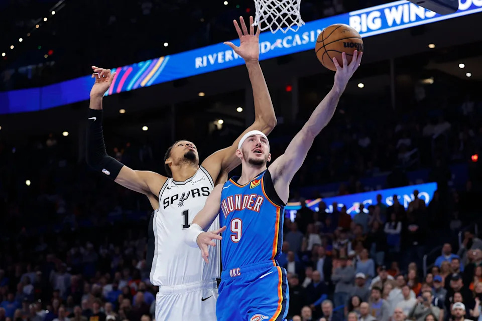 Jan 13, 2026; Oklahoma City, Oklahoma, USA; Oklahoma City Thunder guard Alex Caruso (9) goes to the basket past San Antonio Spurs forward/center Victor Wembanyama (1) during the second half at Paycom Center. Mandatory Credit: Alonzo Adams-Imagn Images