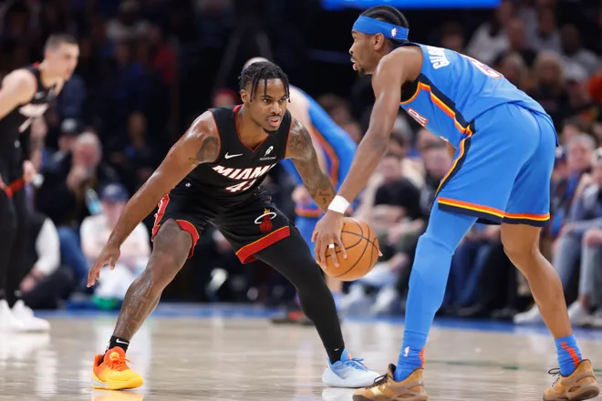 Feb 12, 2025; Oklahoma City, Oklahoma, USA; Miami Heat guard Davion Mitchell (45) defends Oklahoma City Thunder guard Shai Gilgeous-Alexander (2) as he dribbles down the court during the second quarter at Paycom Center. Mandatory Credit: Alonzo Adams-Imagn Images
