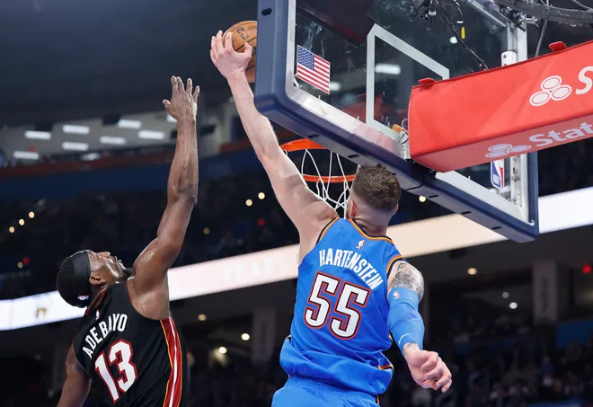 Feb 12, 2025; Oklahoma City, Oklahoma, USA; Oklahoma City Thunder center Isaiah Hartenstein (55) dunks beside Miami Heat center Bam Adebayo (13) during the second half at Paycom Center. Mandatory Credit: Alonzo Adams-Imagn Images