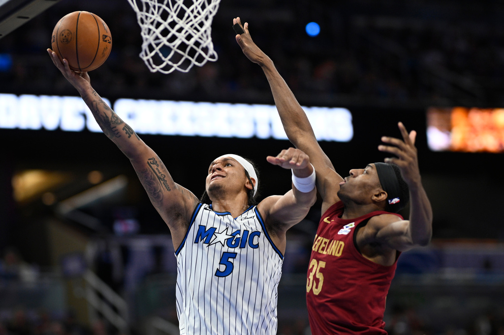 Orlando Magic forward Paolo Banchero (5) goes up to shoot as Cleveland Cavaliers forward Nae'qwan Tomlin (35) defends during the first half of an NBA basketball game, Saturday, Jan. 24, 2026, in Orlando, Fla. (AP Photo/Phelan M. Ebenhack)