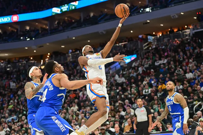 Mar 16, 2025; Milwaukee, Wisconsin, USA; Oklahoma City Thunder guard Shai Gilgeous-Alexander (2) takes a shot against Milwaukee Bucks forward Giannis Antetokounmpo (34) in the second quarter at Fiserv Forum. Mandatory Credit: Benny Sieu-Imagn Images