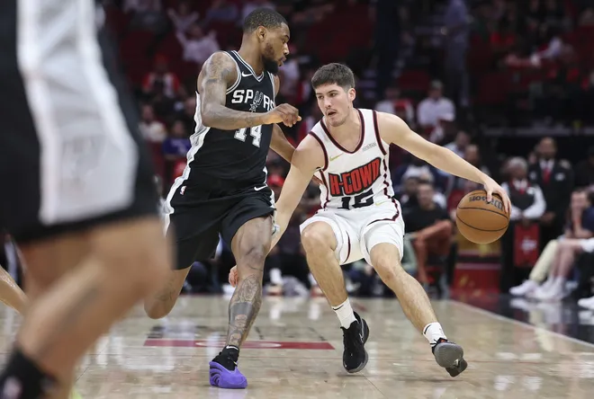 Feb 26, 2025; Houston, Texas, USA; Houston Rockets guard Reed Sheppard (15) dribbles the ball as San Antonio Spurs guard Blake Wesley (14) defends during the fourth quarter at Toyota Center. Mandatory Credit: Troy Taormina-Imagn Images