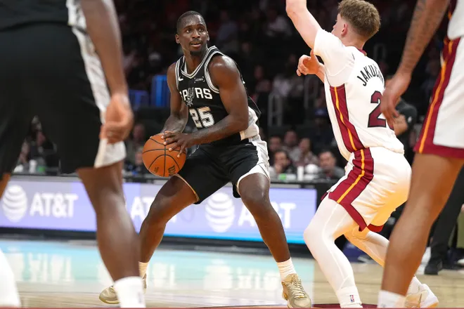 Oct 8, 2025; Miami, Florida, USA; San Antonio Spurs forward David Jones Garcia (25) looks to pass the ball as Miami Heat guard Kasparas Jakucionis (25) defends during the second half at Kaseya Center. Mandatory Credit: Jim Rassol-Imagn Images