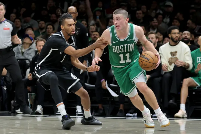 Nov 18, 2025; Brooklyn, New York, USA; Boston Celtics guard Payton Pritchard (11) controls the ball against Brooklyn Nets forward Ziaire Williams (1) during the third quarter at Barclays Center. Mandatory Credit: Brad Penner-Imagn Images