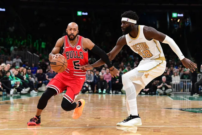 Jan 5, 2026; Boston, Massachusetts, USA; Chicago Bulls guard Jevon Carter (5) controls the ball while Boston Celtics center Neemias Queta (88) defends during the second half at TD Garden. Mandatory Credit: Bob DeChiara-Imagn Images