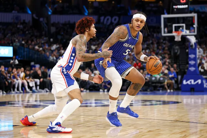 Jan 9, 2026; Orlando, Florida, USA; Orlando Magic forward Paolo Banchero (5) is guarded by Philadelphia 76ers guard Kelly Oubre Jr. (9) in the fourth quarter at Kia Center. Mandatory Credit: Nathan Ray Seebeck-Imagn Images