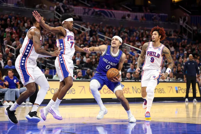 Jan 9, 2026; Orlando, Florida, USA; Orlando Magic guard Anthony Black (0) drives to the basket past Philadelphia 76ers guard Vj Edgecombe (77) in the fourth quarter at Kia Center. Mandatory Credit: Nathan Ray Seebeck-Imagn Images