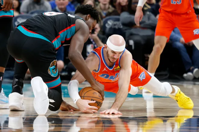 Jan 9, 2026; Memphis, Tennessee, USA; Memphis Grizzlies forward/center Jaren Jackson Jr. (8) and Oklahoma City Thunder guard Alex Caruso (9) dive for a loose ball during the second quarter at FedExForum. Mandatory Credit: Petre Thomas-Imagn Images