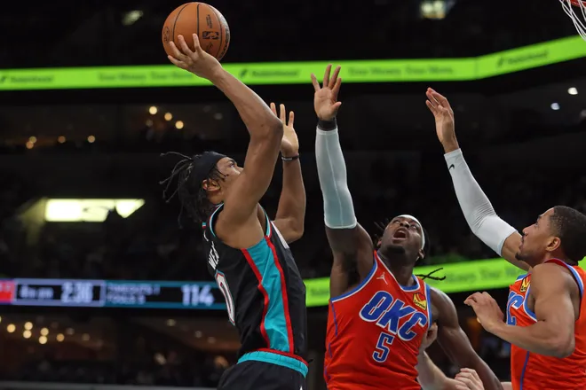 Jan 9, 2026; Memphis, Tennessee, USA; Memphis Grizzlies forward Jaylen Wells (0) shoots as Oklahoma City Thunder guard Luguentz Dort (5) and guard Aaron Wiggins (21) defend during the fourth quarter at FedExForum. Mandatory Credit: Petre Thomas-Imagn Images