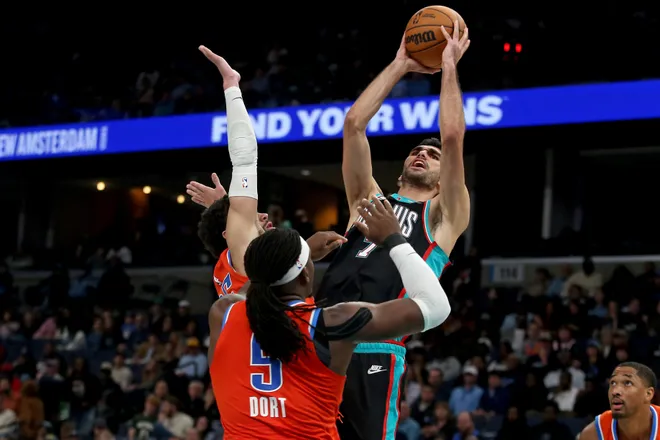 Jan 9, 2026; Memphis, Tennessee, USA; Memphis Grizzlies forward Santi Aldama (7) shoots as Oklahoma City Thunder guard Ajay Mitchell (25) and guard Luguentz Dort (5) defend during the fourth quarter at FedExForum. Mandatory Credit: Petre Thomas-Imagn Images