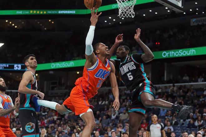 Jan 9, 2026; Memphis, Tennessee, USA; Oklahoma City Thunder guard Aaron Wiggins (21) drives to the basket as Memphis Grizzlies forward Vince Williams Jr. (5) defends during the second quarter at FedExForum. Mandatory Credit: Petre Thomas-Imagn Images