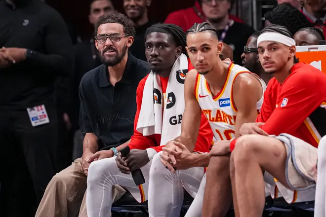 Jan 7, 2026; Atlanta, Georgia, USA; Atlanta Hawks guard Trae Young (11) (left in black shirt) sits on the end of the bench during the game against the New Orleans Pelicans during the second half at State Farm Arena. Mandatory Credit: Dale Zanine-Imagn Images