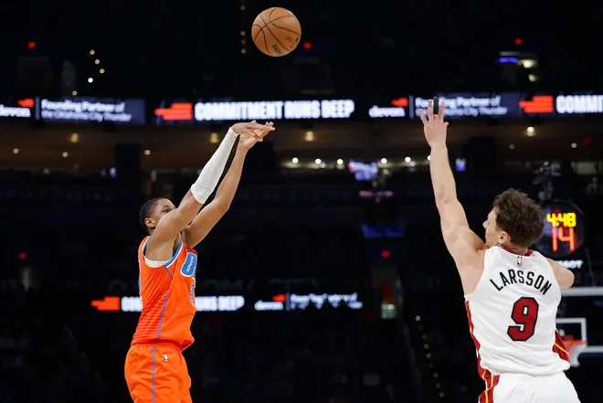 Jan 11, 2026; Oklahoma City, Oklahoma, USA; Oklahoma City Thunder guard Aaron Wiggins (21) shoots a three point basket over Miami Heat guard Pelle Larsson (9) during the second half at Paycom Center. Mandatory Credit: Alonzo Adams-Imagn Images