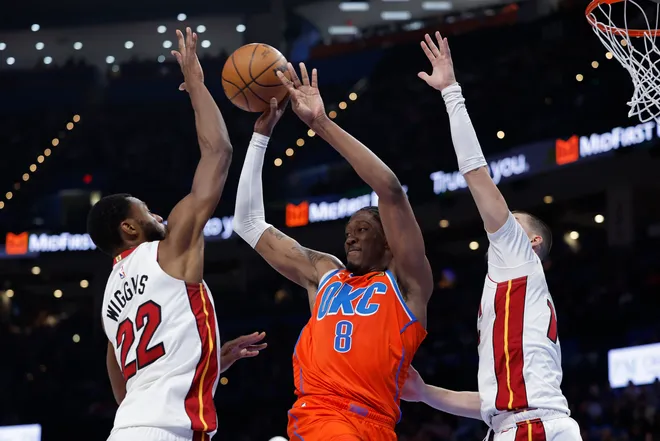 Jan 11, 2026; Oklahoma City, Oklahoma, USA; Oklahoma City Thunder guard/forward Jalen Williams (8) passes between Miami Heat forward Andrew Wiggins (22) and center Kel'el Ware (7) during the second half at Paycom Center. Mandatory Credit: Alonzo Adams-Imagn Images
