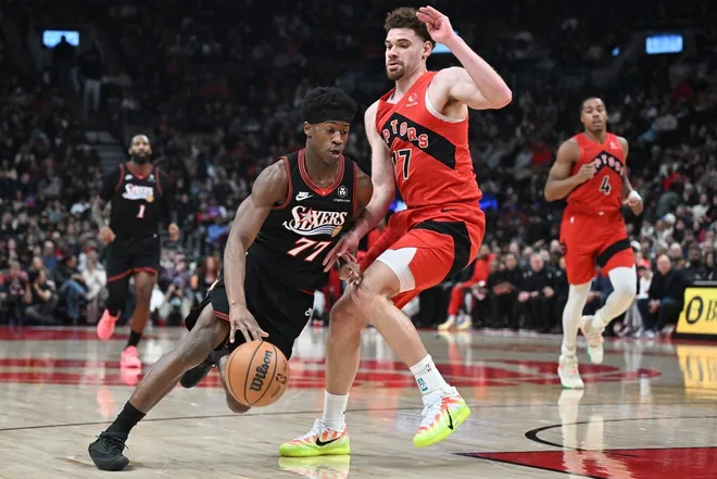 Jan 11, 2026; Toronto, Ontario, CAN; Philadelphia 76ers guard VJ Edgecombe (77) dribbles the ball around Toronto Raptors forward Jamison Battle (77) in the first half at Scotiabank Arena.
