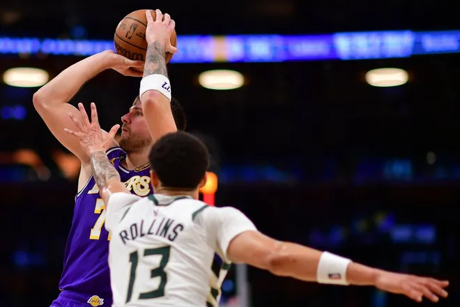 Jan 9, 2026; Los Angeles, California, USA; Los Angeles Lakers guard Luka Doncic (77) shoots against Milwaukee Bucks guard Ryan Rollins (13) during the second half at Crypto.com Arena.