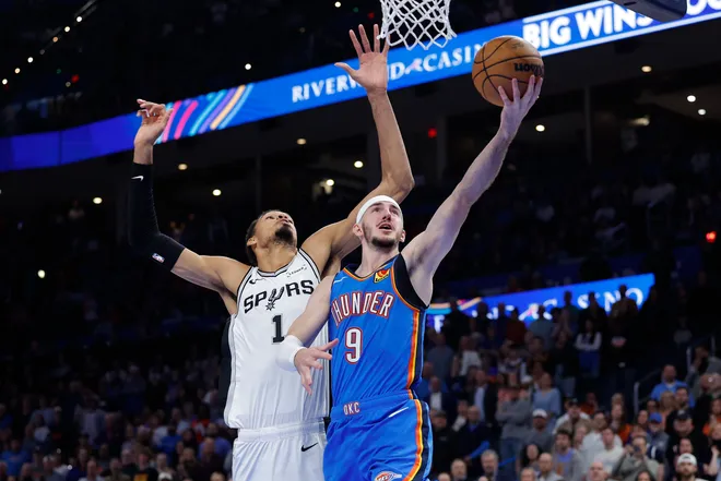 Jan 13, 2026; Oklahoma City, Oklahoma, USA; Oklahoma City Thunder guard Alex Caruso (9) goes to the basket past San Antonio Spurs forward/center Victor Wembanyama (1) during the second half at Paycom Center. Mandatory Credit: Alonzo Adams-Imagn Images