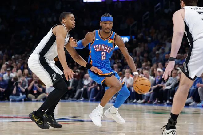 Jan 13, 2026; Oklahoma City, Oklahoma, USA; Oklahoma City Thunder guard Shai Gilgeous-Alexander (2) drives down the court past San Antonio Spurs forward/guard Keldon Johnson (3) during the second half at Paycom Center. Mandatory Credit: Alonzo Adams-Imagn Images