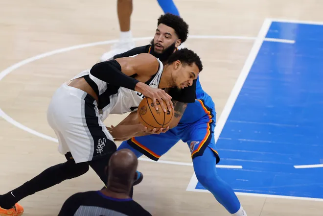 Jan 13, 2026; Oklahoma City, Oklahoma, USA; Oklahoma City Thunder guard/forward Kenrich Williams (34) and San Antonio Spurs forward/center Victor Wembanyama (1) fight for a loose ball during the second half at Paycom Center. Mandatory Credit: Alonzo Adams-Imagn Images