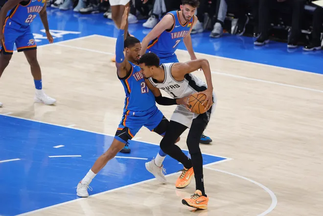 Jan 13, 2026; Oklahoma City, Oklahoma, USA; Oklahoma City Thunder guard Aaron Wiggins (21) defends a drive by San Antonio Spurs forward/center Victor Wembanyama (1) during the first quarter at Paycom Center. Mandatory Credit: Alonzo Adams-Imagn Images
