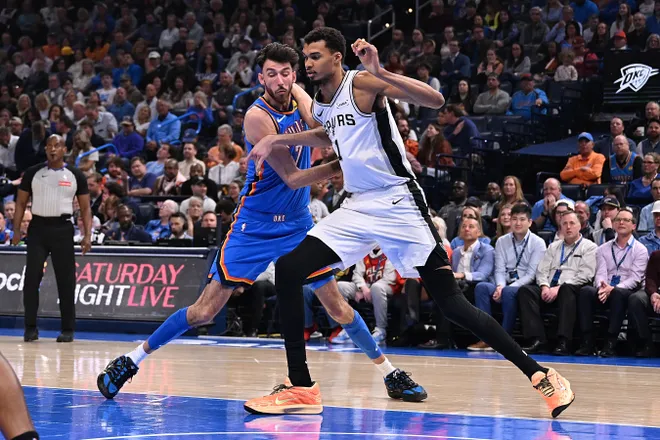 OKLAHOMA CITY, OKLAHOMA - JANUARY 13: Chet Holmgren #7 of the Oklahoma City Thunder and Victor Wembanyama #1 of the San Antonio Spurs battle for a rebound during the first half at Paycom Center on January 13, 2026 in Oklahoma City, Oklahoma. NOTE TO USER: User expressly acknowledges and agrees that, by downloading and or using this photograph, User is consenting to the terms and conditions of the Getty Images License Agreement. (Photo by Joshua Gateley/Getty Images)