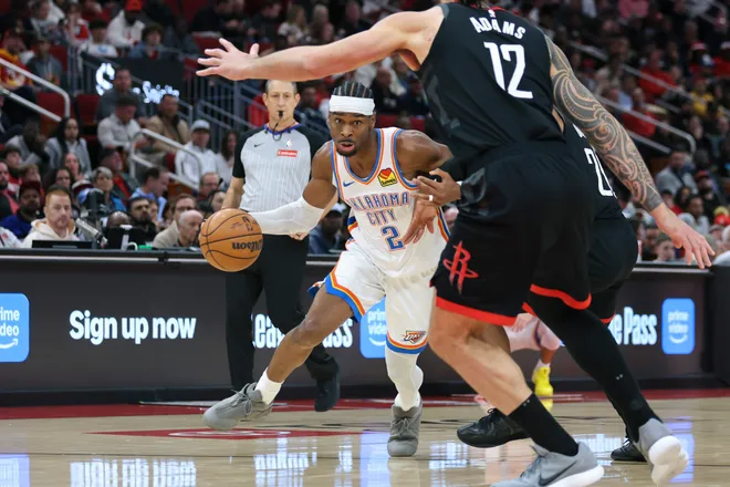 Jan 15, 2026; Houston, Texas, USA; Oklahoma City Thunder guard Shai Gilgeous-Alexander (2) dribbles the ball as Houston Rockets guard Josh Okogie (20) defends during the third quarter at Toyota Center. Mandatory Credit: Troy Taormina-Imagn Images
