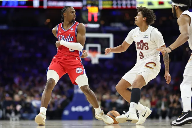 Jan 16, 2026; Philadelphia, Pennsylvania, USA; Philadelphia 76ers guard Tyrese Maxey (0) passes the ball in front of Cleveland Cavaliers guard Craig Porter Jr. (9) during the first quarter at Xfinity Mobile Arena. Mandatory Credit: Bill Streicher-Imagn Images