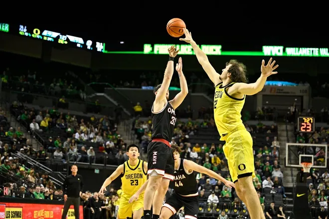 Dec 28, 2025; Eugene, Oregon, USA; Omaha Mavericks guard Tony Osburn (32) shoots the ball over Oregon Ducks center Nate Bittle (32) during the second half at Matthew Knight Arena.