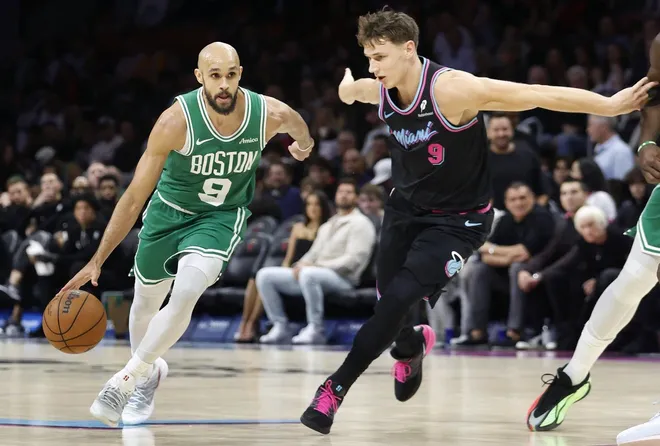 Jan 15, 2026; Miami, Florida, USA; Boston Celtics guard Derrick White (9) dribbles the ball past Miami Heat guard Pelle Larsson (9) during the second half at Kaseya Center.