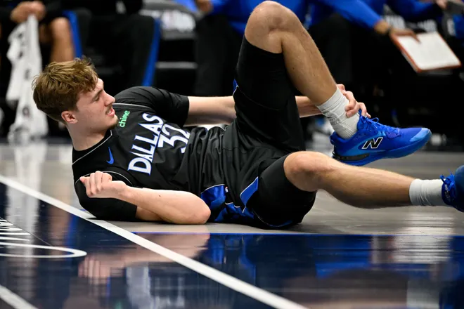 Jan 14, 2026; Dallas, Texas, USA; Dallas Mavericks forward Cooper Flagg (32) grabs his ankle as he falls to the floor during the second quarter against the Denver Nuggets at the American Airlines Center. Mandatory Credit: Jerome Miron-Imagn Images