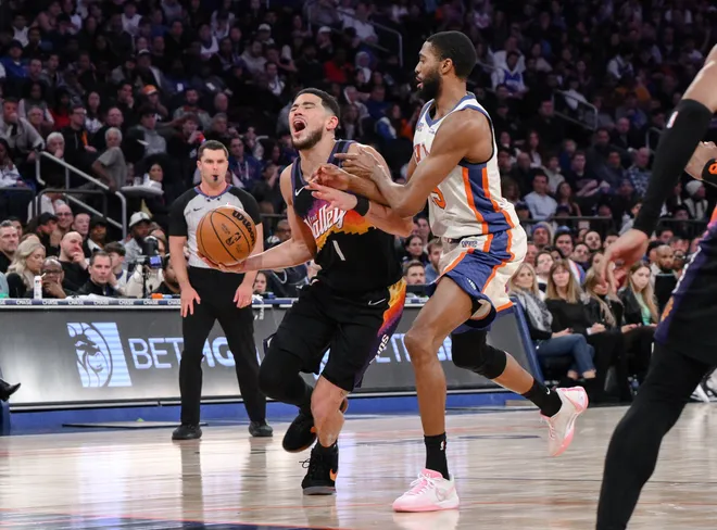Jan 17, 2026; New York, New York, USA; Phoenix Suns guard Devin Booker (1) tries to drive past New York Knicks guard Mikal Bridges (25) during the second half at Madison Square Garden. Mandatory Credit: John Jones-Imagn Images