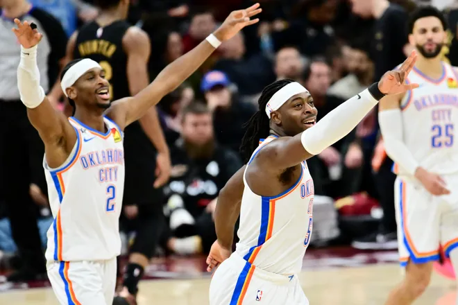 Jan 19, 2026; Cleveland, Ohio, USA; Oklahoma City Thunder guard Luguentz Dort (5) and guard Shai Gilgeous-Alexander (2) celebrate after a three point basket during the second half against the Cleveland Cavaliers at Rocket Arena. Mandatory Credit: Ken Blaze-Imagn Images