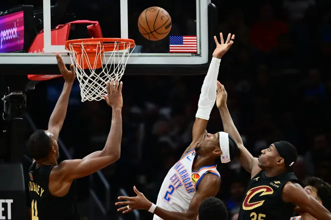 Jan 19, 2026; Cleveland, Ohio, USA; Oklahoma City Thunder guard Shai Gilgeous-Alexander (2) drives to the basket between Cleveland Cavaliers center Evan Mobley (4) and forward Nae'qwan Tomlin (35) during the second half at Rocket Arena. Mandatory Credit: Ken Blaze-Imagn Images