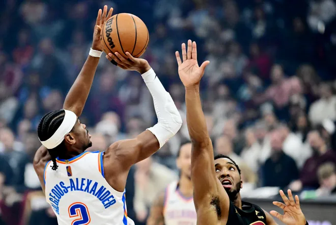 Jan 19, 2026; Cleveland, Ohio, USA; Oklahoma City Thunder guard Shai Gilgeous-Alexander (2) shoots over the defense of Cleveland Cavaliers guard Donovan Mitchell (45) during the first quarter at Rocket Arena. Mandatory Credit: Ken Blaze-Imagn Images