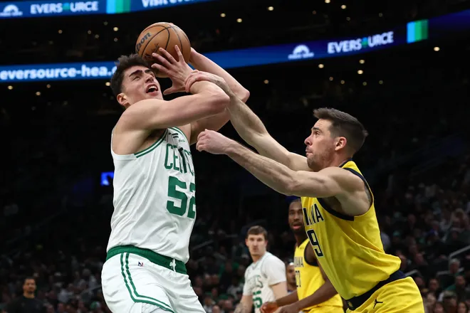 Jan 21, 2026; Boston, Massachusetts, USA; Indiana Pacers guard T.J. McConnell (9) fouls Boston Celtics center Luka Garza (52) going to the basket during the first quarter at TD Garden. Mandatory Credit: Winslow Townson-Imagn Images