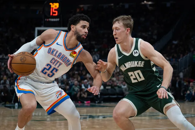 Oklahoma City Thunder guard Ajay Mitchell (25) drives past Milwaukee Bucks guard AJ Green (20) in the second half at Fiserv Forum on the evening of Jan. 21, 2026 in Milwaukee, Wisconsin.