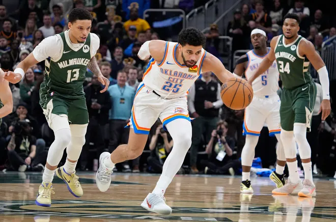 Jan 21, 2026; Milwaukee, Wisconsin, USA; Oklahoma City Thunder guard Ajay Mitchell (25) strips the ball away from Milwaukee Bucks guard Ryan Rollins (13) in the first half at Fiserv Forum. Mandatory Credit: Michael McLoone-Imagn Images