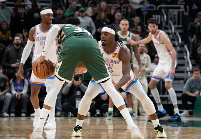 Jan 21, 2026; Milwaukee, Wisconsin, USA; Oklahoma City Thunder guard Luguentz Dort (5) plays defense against Milwaukee Bucks forward Giannis Antetokounmpo (34) in the first half at Fiserv Forum. Mandatory Credit: Michael McLoone-Imagn Images