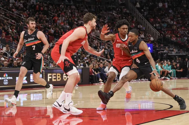Jan 20, 2026; Houston, Texas, USA;San Antonio Spurs guard De'aaron Fox (4) dribbles against Houston Rockets guard Amen Thompson (1) in the fourth quarter at Toyota Center.