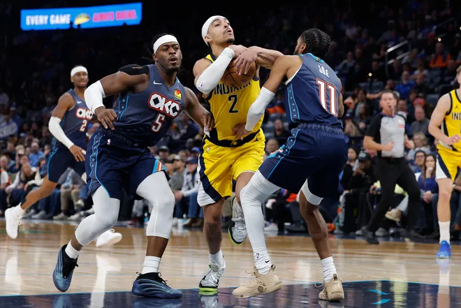 Jan 23, 2026; Oklahoma City, Oklahoma, USA; Indiana Pacers guard/forward Andrew Nembhard (2) drives between Oklahoma City Thunder guard Luguentz Dort (5) and guard Isaiah Joe (11) during the second half at Paycom Center. Mandatory Credit: Alonzo Adams-Imagn Images