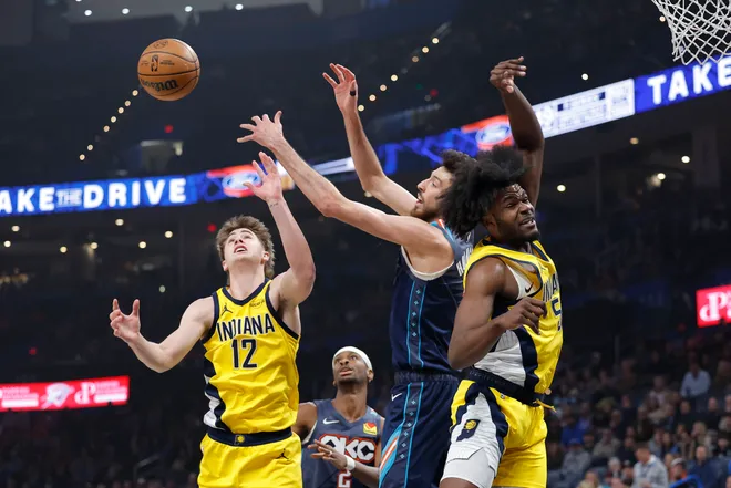 Jan 23, 2026; Oklahoma City, Oklahoma, USA; Indiana Pacers guard Johnny Furphy (12) and Oklahoma City Thunder center/forward Chet Holmgren (7) reach for a rebound during the first quarter at Paycom Center. Mandatory Credit: Alonzo Adams-Imagn Images
