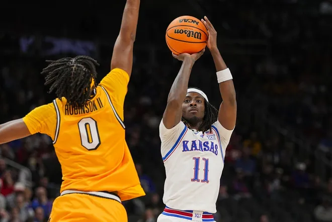 Dec 7, 2025; Kansas City, Missouri, USA; Kansas Jayhawks guard Jamari McDowell (11) shoots against Missouri Tigers guard Anthony Robinson II (0) during the first half at T-Mobile Center.