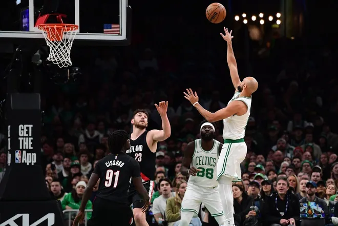 Jan 26, 2026; Boston, Massachusetts, USA; Boston Celtics guard Derrick White (9) shoots the ball over Portland Trail Blazers guard Sidy Cissoko (91) and center Donovan Clingan (23) during the first half at TD Garden.