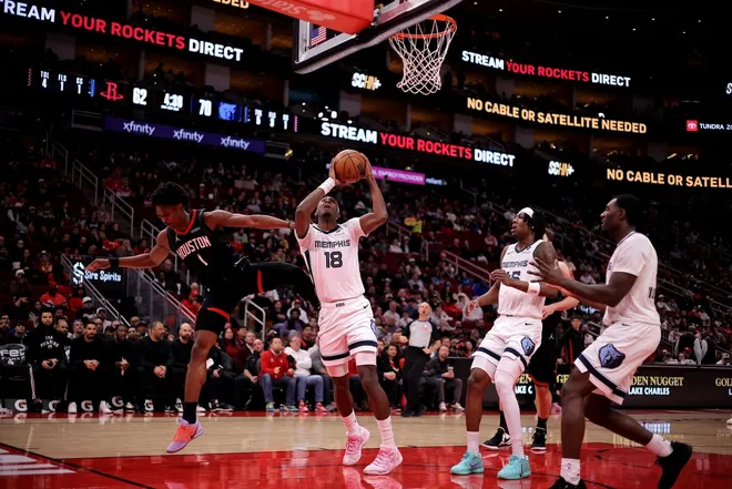 Jan 26, 2026; Houston, Texas, USA; Memphis Grizzlies forward Olivier-Maxence Prosper (18) is fouled by Houston Rockets guard Amen Thompson (1) while shooting during the third quarter at Toyota Center.