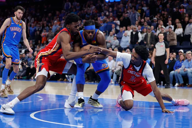 Jan 27, 2026; Oklahoma City, Oklahoma, USA; New Orleans Pelicans center Yves Missi (21) and forward Herbert Jones (2) fight for the ball against Oklahoma City Thunder guard Luguentz Dort (5) during the second half at Paycom Center. Mandatory Credit: Alonzo Adams-Imagn Images